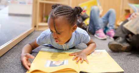 Child lying on the floor reading a book