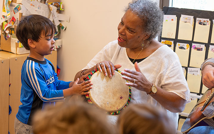 Teacher and boy in a Reggio setting drumming and making music