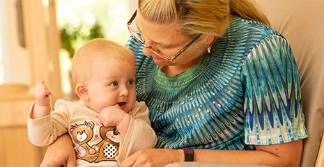 Teacher holding an infant.