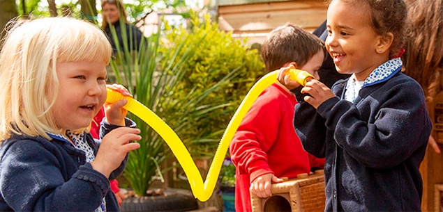 two girls playing with yellow pipe