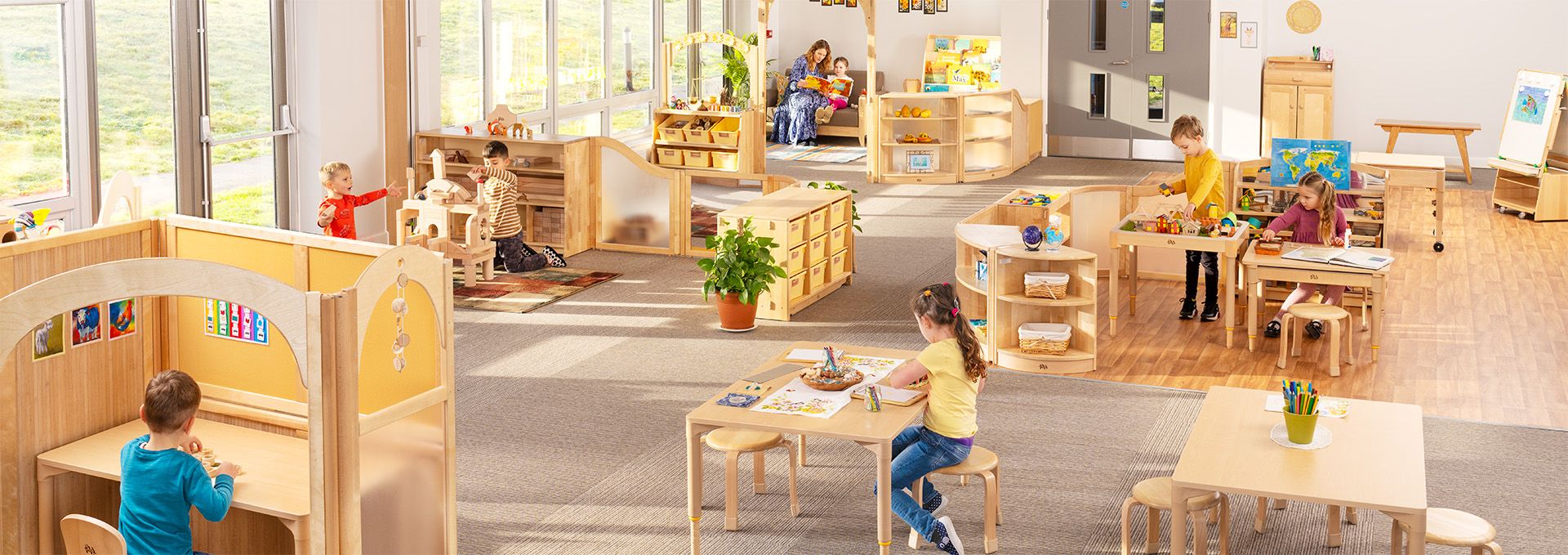 Children playing and learning in a bright, open classroom with Roomscapes furniture and dividers.