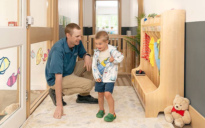 Child and teacher in front of locker