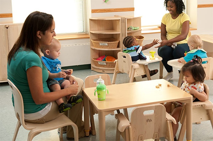 babies and toddlers and teacher eating at community playthings multitables