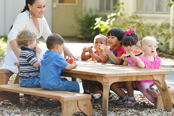 two year olds and teacher eating at a community playthings outlast table