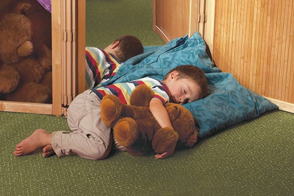 boy asleep on pillow with mirror and bamboo panels in background