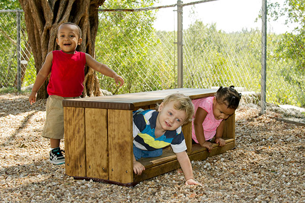 3 toddlers crawling and playing in and by the outlast storage bench