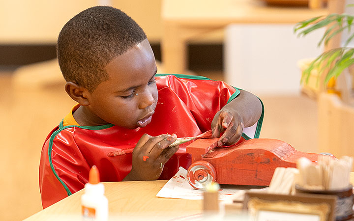 Child painting a toy car