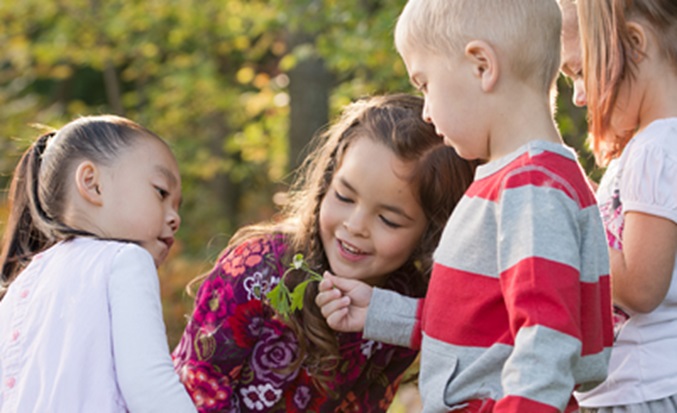 4 kids looking at a leaf