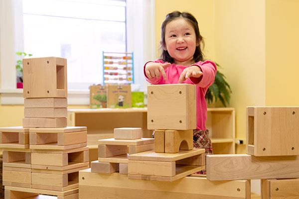 little girl playing with wooden blocks