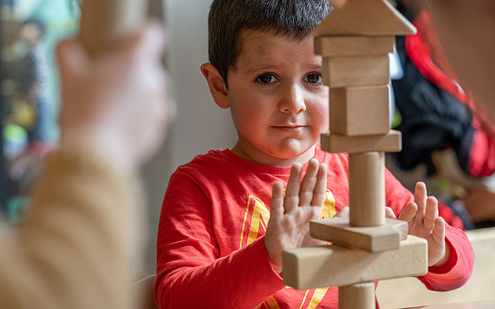 A boy examining his block tower