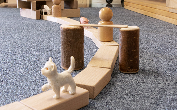 A road made with community playthings building blocks laid end to end, with toy animals on them.