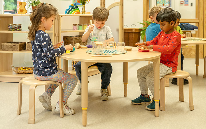 three children sitting on stools