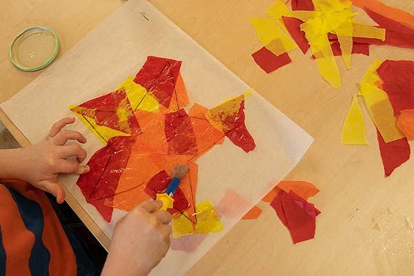 Star completely covered in coloured tissue with childs hands