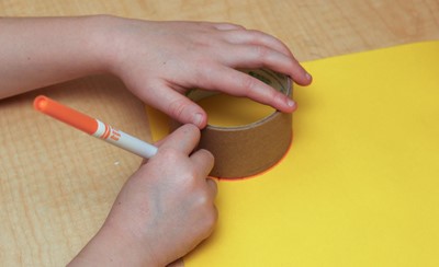 Child's hands drawing a circle on paper