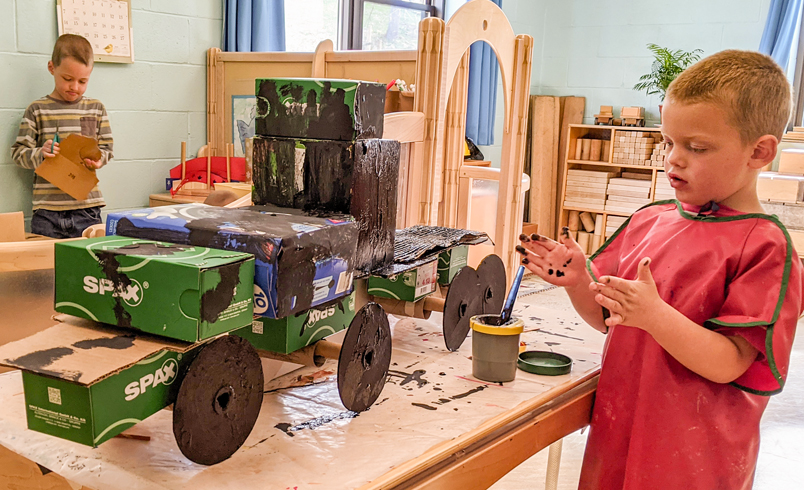 Boy constructing cardboard lorry