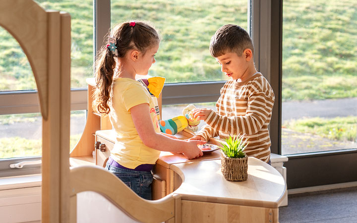 Two children playing store in the role play corner