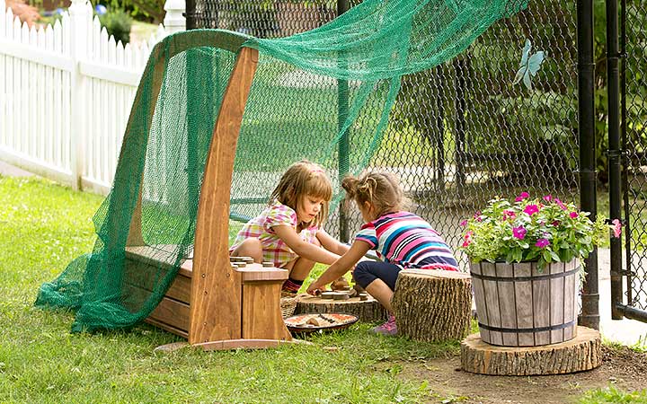 Two girls play in outdoor den