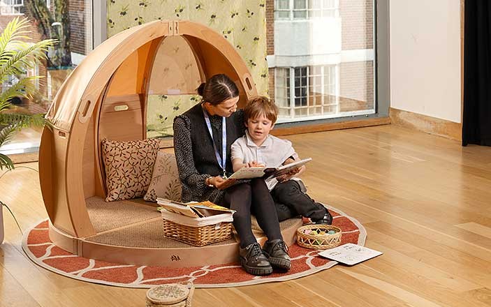 Teacher interacts with child on platform of FlexiDen