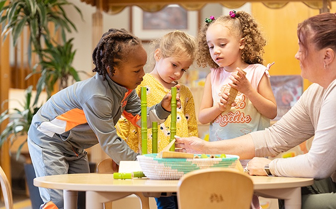 3 kids with teacher at table