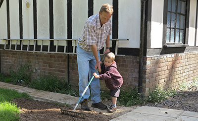 father showing son how to rake