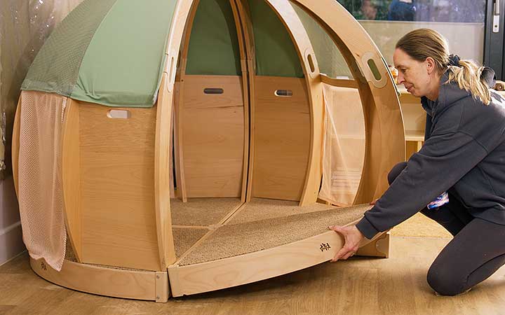 A teacher assembling a solid wood den or regulation space.