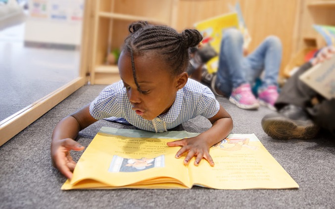 Girl lying on the floor reading a book