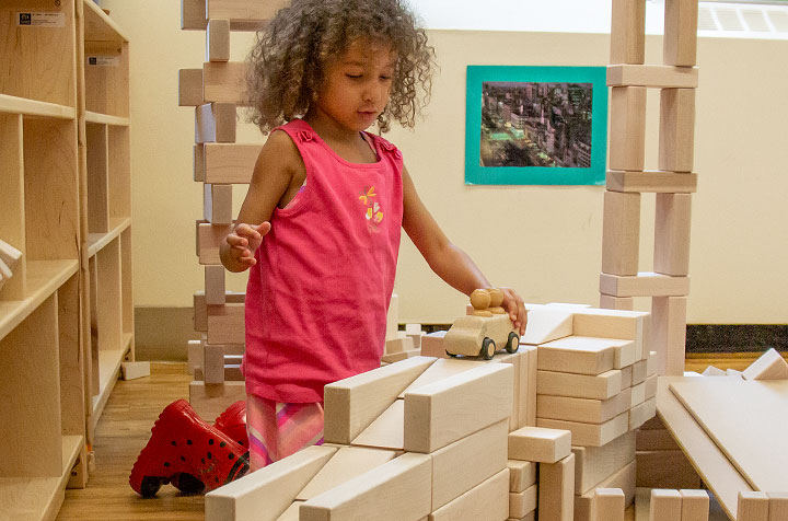 Girl building a ramp out of wooden blocks