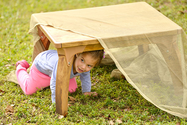 girl playing in den under table
