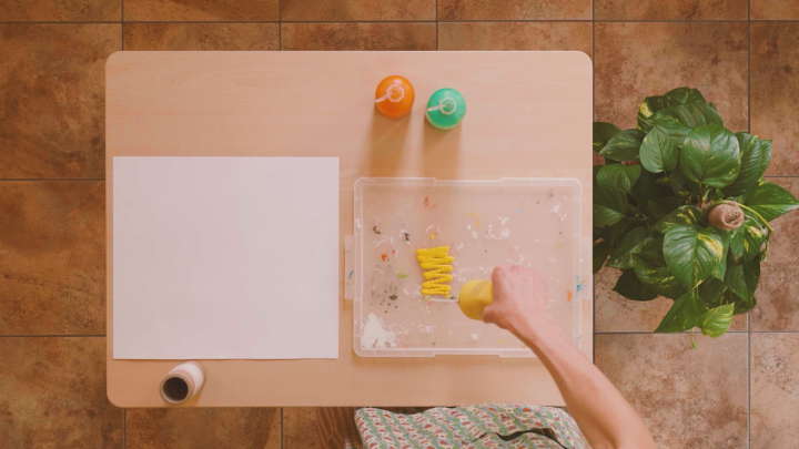 hand squirting poster paint onto plastic tray