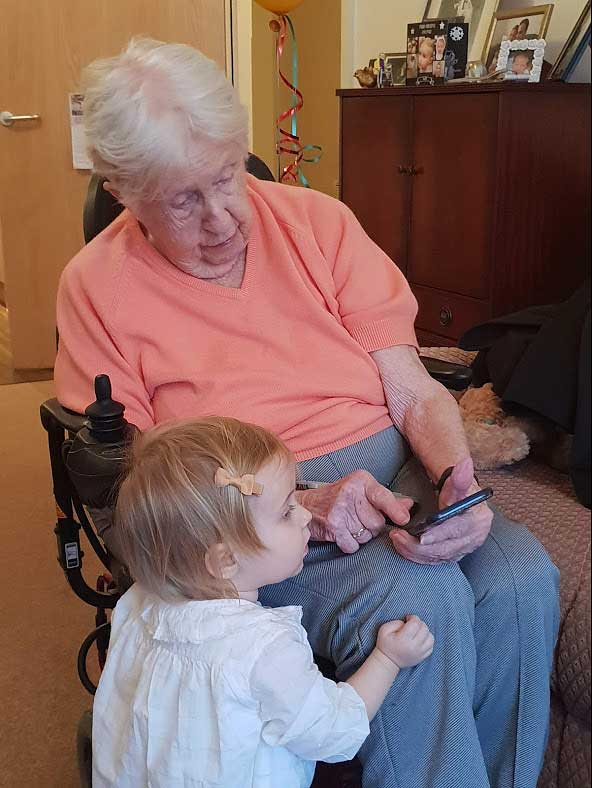 Elderly lady and toddler looking at phone