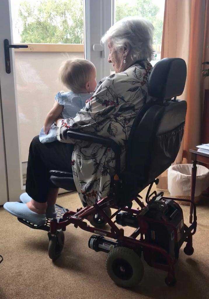 Irene in wheelchair holding Pixie on her lap.