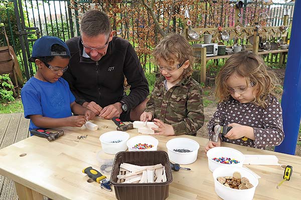 Pete Moorhouse with 3 children around workbench