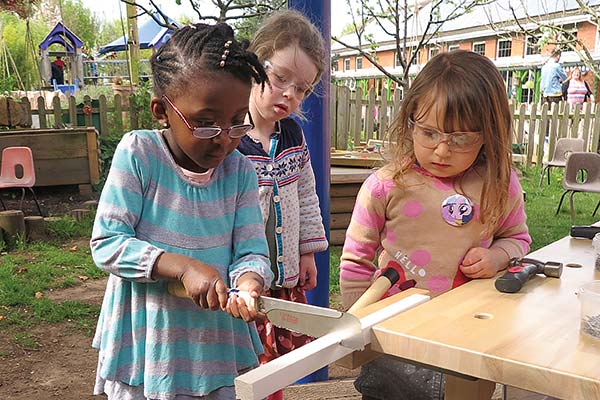 girl sawing with 2 onlookers