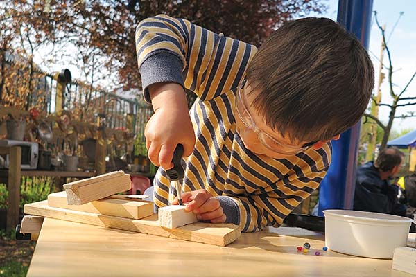 boy in striped shirt turning a screw