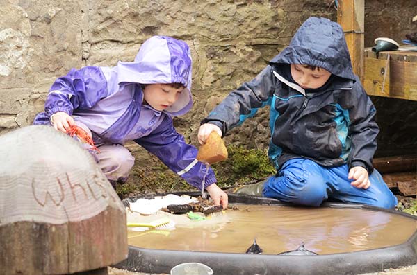 two children playing in a puddle