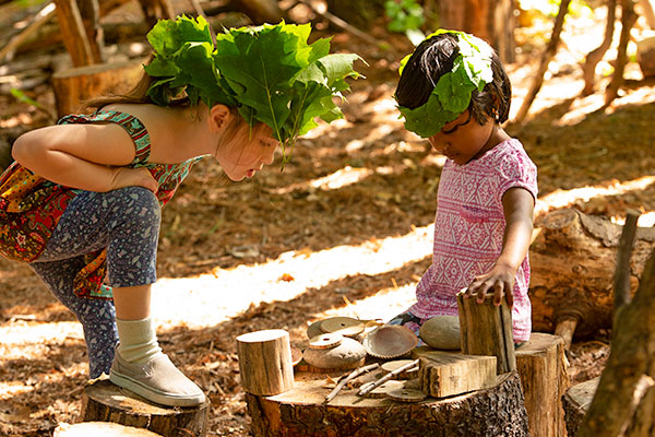 two girls enjoying role play outdoors