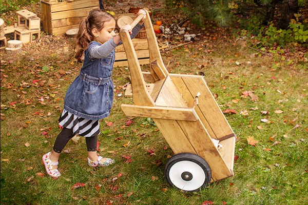 little girl playing with Outlast wheelbarrow
