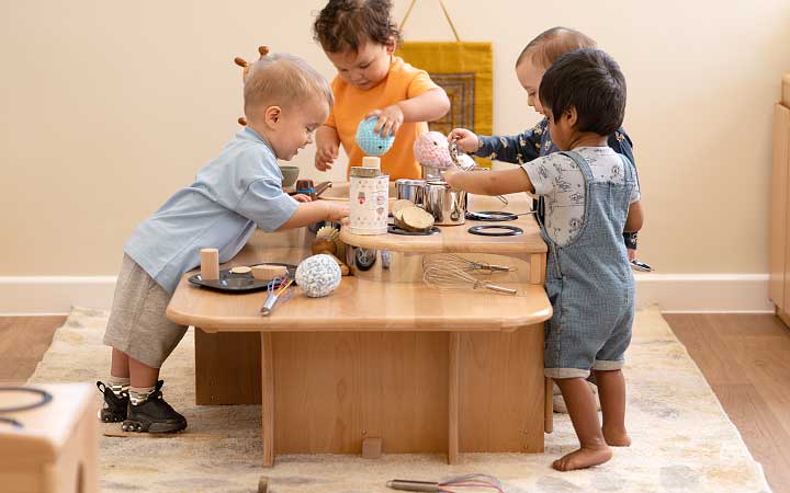 Four babies play at the kitchen island.