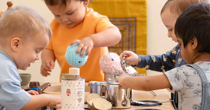 Close up shot of four toddlers engaged in role play.