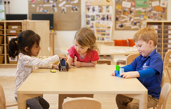 reception age children playing at a table