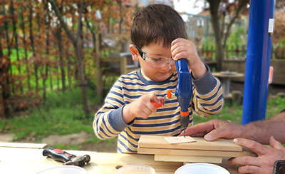 Boy using tools at Workbench