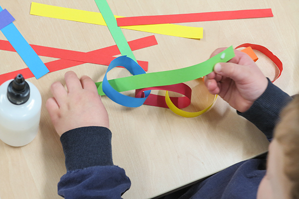 sliding paper strip through a ring on a paper chain
