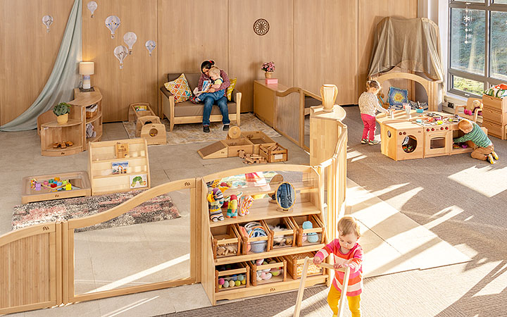 A baby room environment set up with solid wood furniture, natural materials, and beautiful calming colours