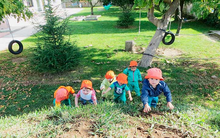 Preschool children climbing up a hill