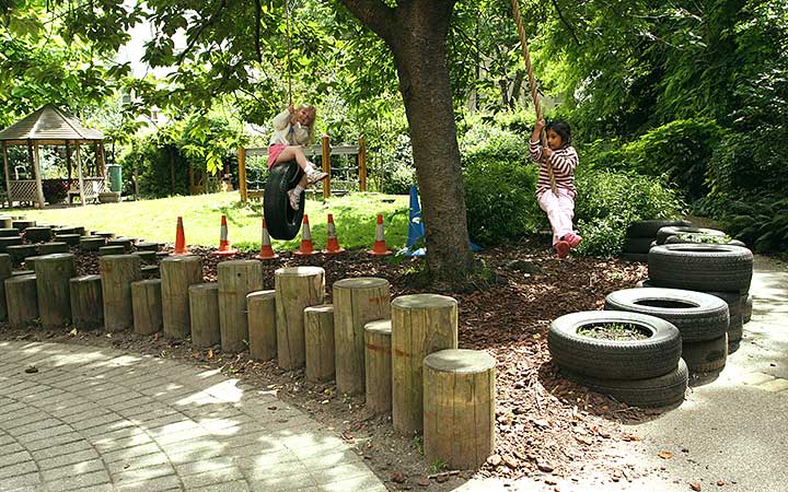 Two children swing on hanging tires