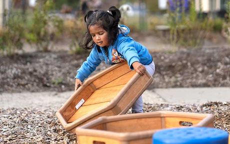 A girl lifting a wooden box