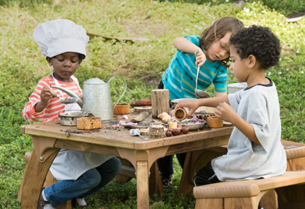 three children doing mud play at an outlast table