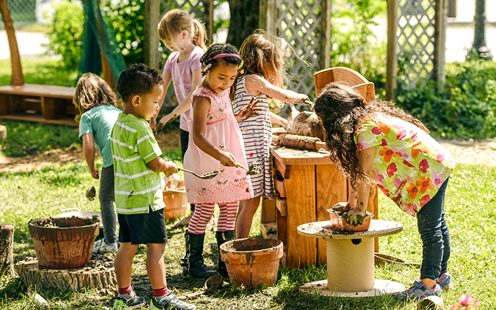 children playing with mud in an outdoor mud kitchen