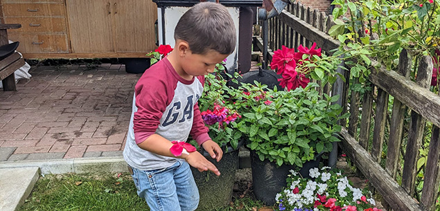 child sticking petals on bracelet