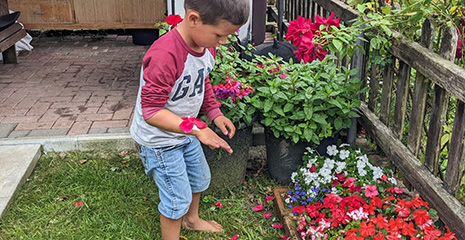 boy sticking petals to nature bracelet